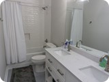 Hallway bathroom with double sinks, tub and shower.